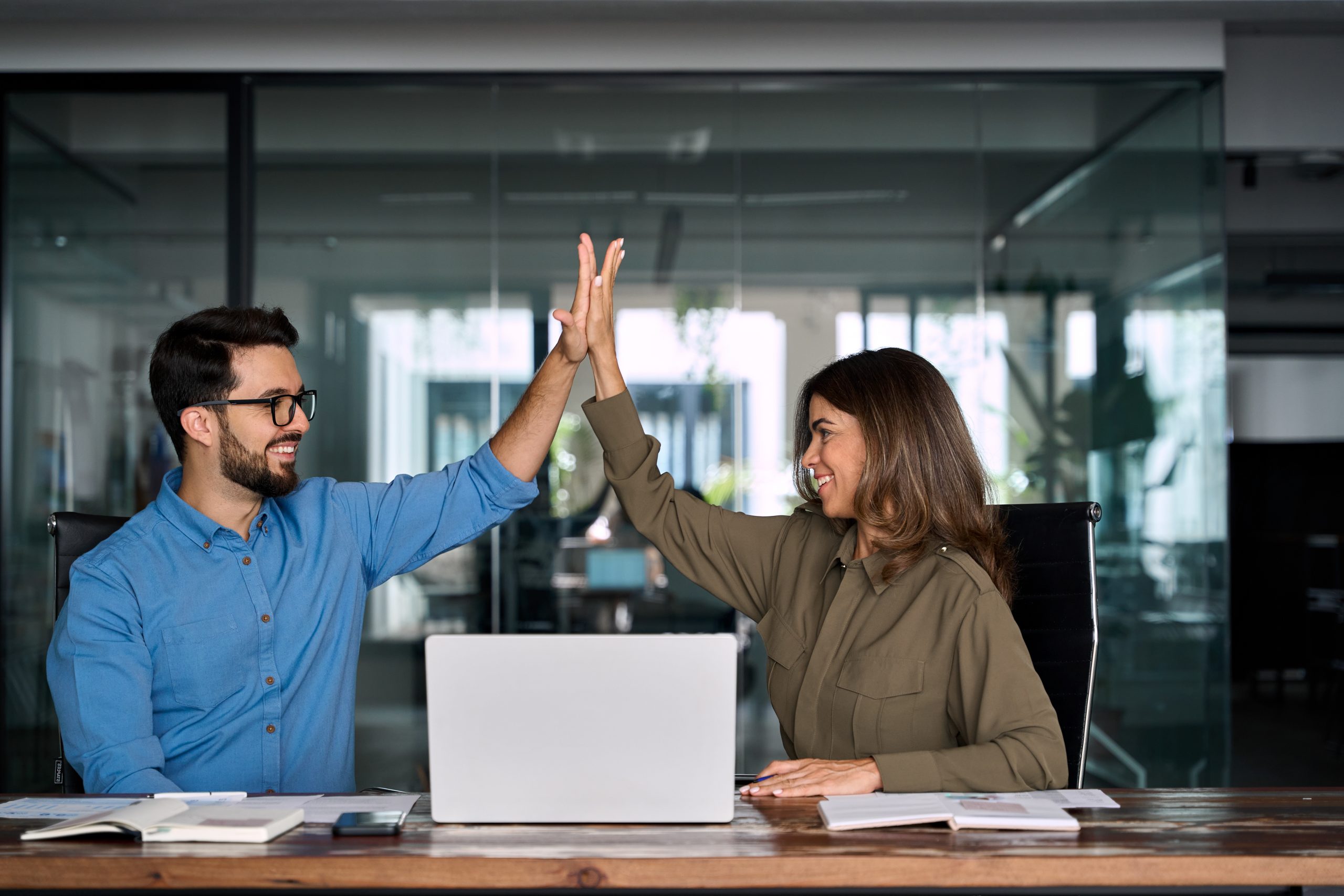 happy business team two employees give high five celebrate professional success.